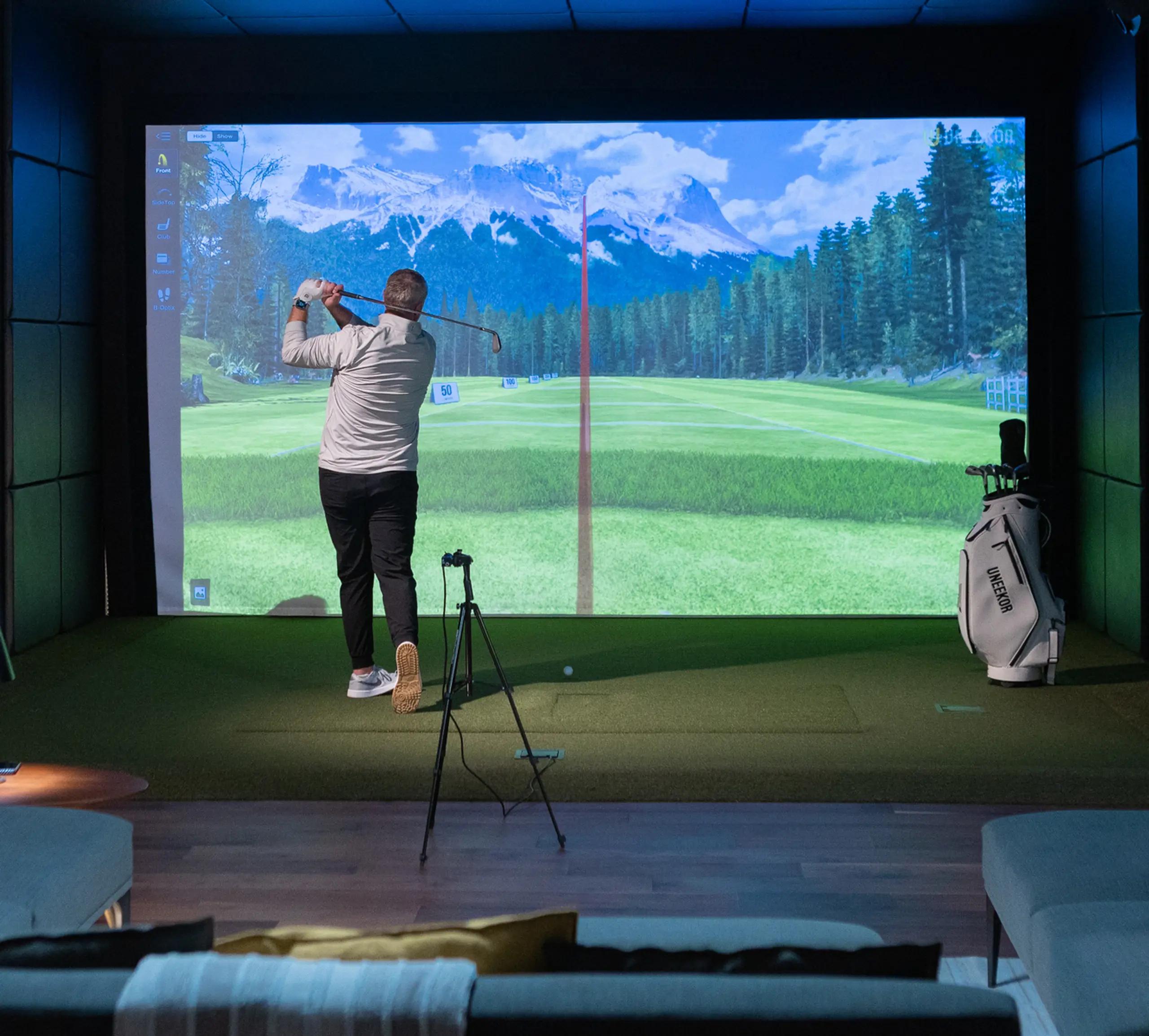 Finished home golf simulator room with a large impact screen